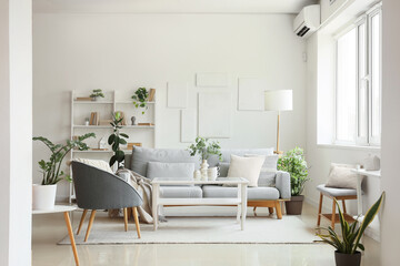 Comfortable sofa, floor lamp, table and armchair in interior of living room