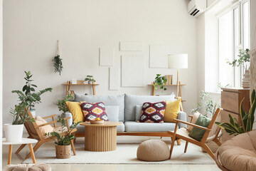 Interior of living room with comfortable sofa, armchairs, table and houseplants