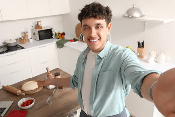 Male blogger cooking while recording video in kitchen