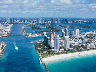 Fototapeta premium Aerial view of South Pointe Beach, Fisher Island, and Downtown Miami skyline under blue sky. c.