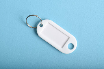 White plastic key tag isolated on light blue background