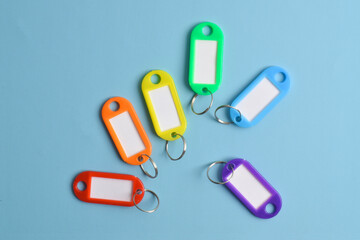 Colorful plastic key tag isolated on light blue background