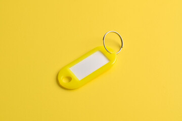 Yellow plastic key tag isolated on yellow background