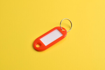 Red plastic key tag isolated on yellow background