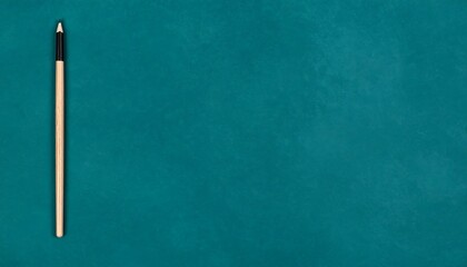 A light beige pencil on a teal background