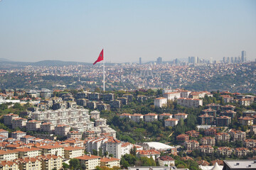 City view of urban landscape with Turkish flag on hill