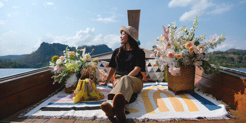 A woman sitting on a long tail boat while traveling on the river
