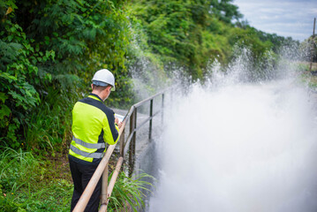 A dam specialist engineer is checking the operation of a large dam's water release system to ensure...