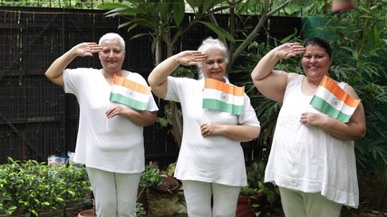 Proud patriotic senior women holding indian flag saluting and celebrating Independence day or Republic day. 15th August, 26 January. People of india. Patriotism. 4k, 60s