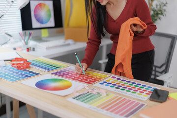 Fashion designer choosing colors for new clothes collection using palette