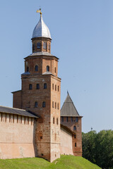 Obraz premium Historic red-brick towers of Veliky Novgorod Kremlin with silver dome and wooden roof, preserved from medieval Russian architecture.