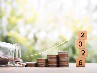 Stack of coins with arrow rising up. The concept of saving money, Financial, Investment and Business growing up in year 2026.