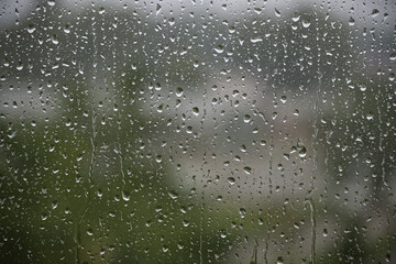 Rain Drops on Glass Window With Blurry Outdoor Background in Focus