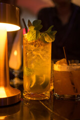 Popular cocktail on table on night background with shadow. Cocktail on coloured background in trendy style. Contemporary concept with alcohol beverage. Bartender cocktail