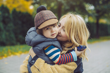Loving Mother Hugging Her Son Outdoors in Autumn Park