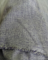 A detailed macro shot of two-tone purple woven fabric with visible weave pattern and finished hem....