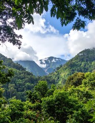 Fototapeta premium A breathtaking view of majestic mountains towering above, framed by lush green trees below, with a clear blue sky and soft clouds enhancing the scenery.