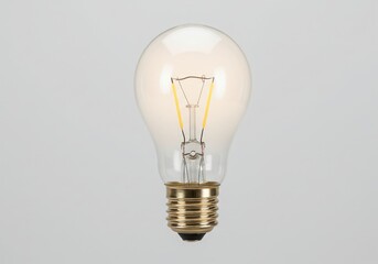 Close up of a glowing incandescent light bulb with a clear glass bulb