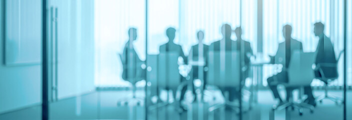 Blurred business people in suits sit at a table in modern office.