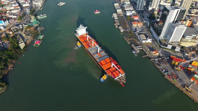 Cargo ship navigating through a narrow waterway near a coastal municipality port area of Itaja&iacute;, Santa Catarina, Brazil.