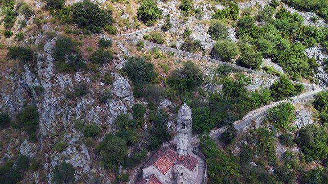 Tourists climb stone staircase above Lady of Remedy church, Kotor MNE