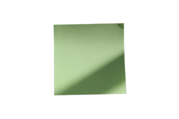 A light sage green sticky note, square, isolated on black.  Shadow falls diagonally across