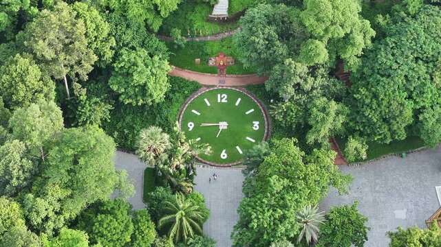 Aerial video of Phnom Penh&rsquo;s Wat Phnom Park shows the iconic hilltop clock embedded in lush greenery, surrounded by shaded walking paths and tall trees.