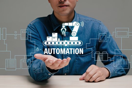 Man presenting a digital infographic of a robotic arm on a conveyor belt with the word automation symbolizing industrial efficiency