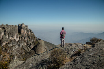 Fototapeta premium Male person in trekin clothing standing looking at the horizon in the Marcahuasi mountain chasm.