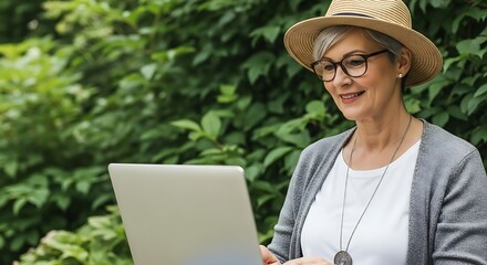 Woman with hat and glasses using laptop outdoors image