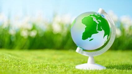 Colorful globe on a green lawn under clear blue sky highlighting the beauty of Earth