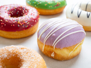 Donuts with different colorful icing designs on a white background.