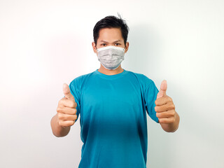 A Young Asian Man Wearing a Mask Giving a Thumbs Up Gesture for Health Safety