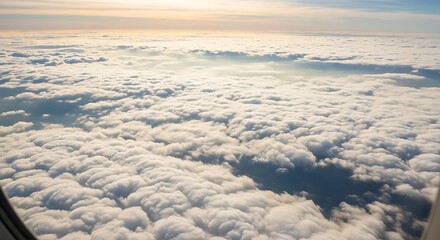 Obraz premium Aerial view of a vast expanse of fluffy clouds illuminated by the warm glow of the setting or rising sun.