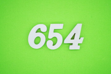 The numbers are made of white painted wood and placed on a green paper background.