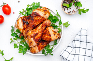 Baked chicken legs or drumsticks, white table background, top view
