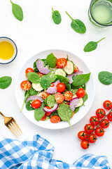 Vegan vegetable fresh salad with spinach, tomatoes, cucumber, onion, sesame and olive oil