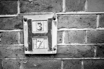 Vintage analog monochrome photography of number 37 sign on brick wall