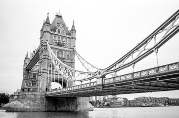 Tower bridge standing majestically over thames river in monochrome film style