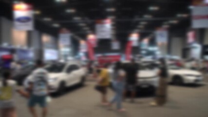 Car event held in a shopping mall. People walking around. Blurry and soft focus. There is slight camera shake.