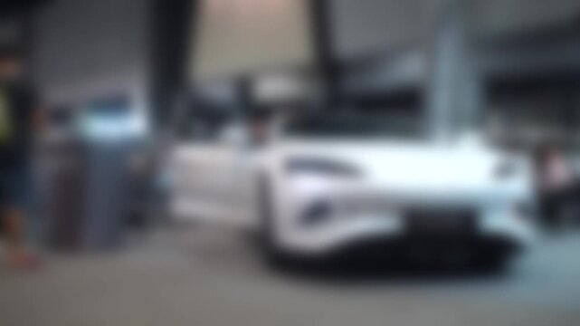 Car event held in a shopping mall. People walking around. Blurry and soft focus. There is slight camera shake.