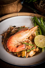 Close-up photo of dry Pad Thai noodles with tamarind sauce mixed with egg and minced tofu. Thai food.