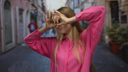 Fototapeta premium Woman laughing joyfully on a bustling city street, wearing a vibrant pink shirt, capturing a moment of happiness and carefree expression in an outdoor urban setting.