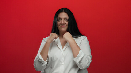 Young plus size woman boxing with confidence against a bold red background, focusing on empowerment and determination.
