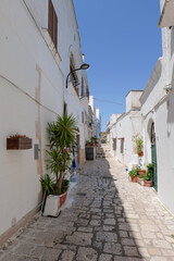 A narrow street among the white houses of Ginosa, an Apulian village, Italy.
