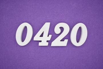 The numbers are made of white painted wood, placed on a purple paper background.