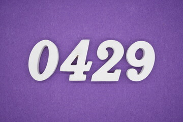 The numbers are made of white painted wood, placed on a purple paper background.