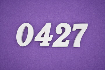 The numbers are made of white painted wood, placed on a purple paper background.