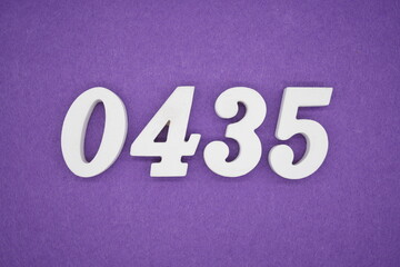 The numbers are made of white painted wood, placed on a purple paper background.