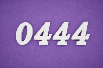 The numbers are made of white painted wood, placed on a purple paper background.